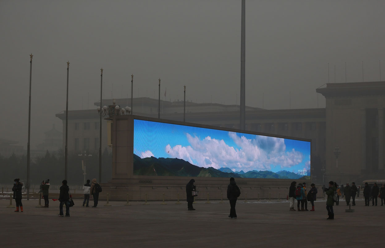 A bright video screen shows images of blue sky on Tiananmen Square during a time of dangerous levels of air pollution, on January 23, 2013 in Beijing. (Feng Li/Getty Images)